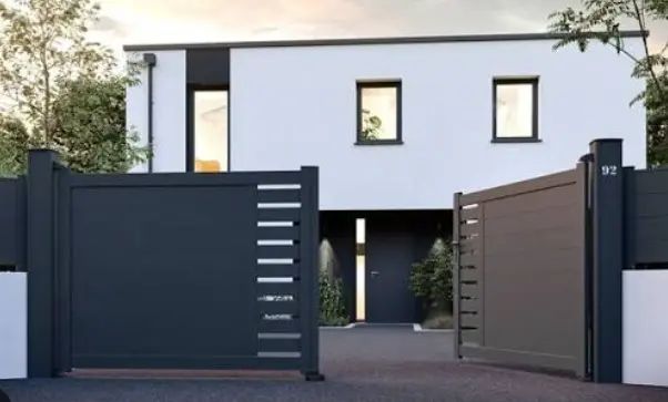 Modern residence with a dark architectural entrance gate and matching fence.